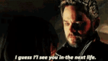 a man and woman are looking at each other in a dark room .