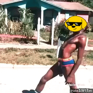 a shirtless man wearing sunglasses and a lemon on his face is walking down a street .