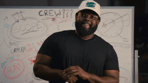 a man standing in front of a white board that says crew on it