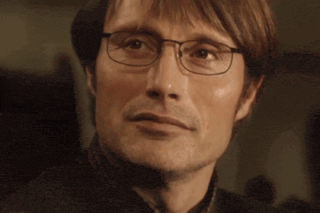 a close up of a man wearing glasses and a plaid shirt