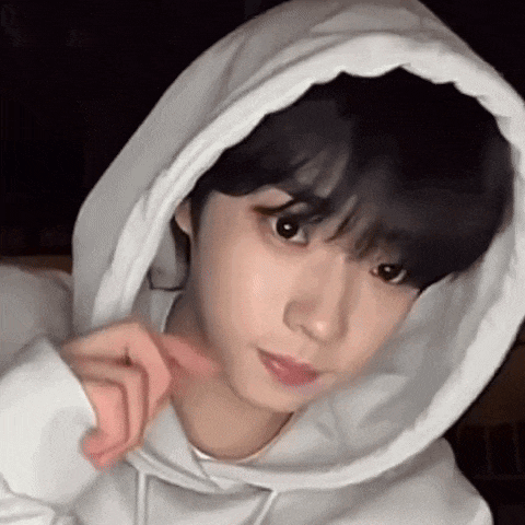 a close up of a person wearing a white hoodie with a hood on their head .
