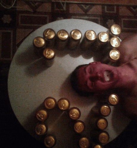 a man is laying on a table surrounded by cans of beer including one that says ' a ' on it