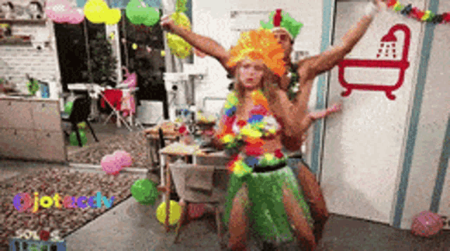 a man and a woman are dancing in a room with balloons and a shower sign on the wall