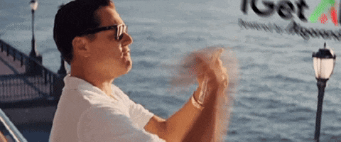 a man wearing sunglasses is sitting on a boat in front of a sign that says get a