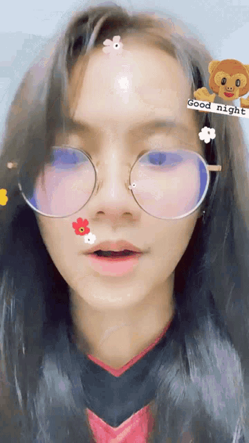 a girl wearing glasses has a sticker on her forehead that says good night