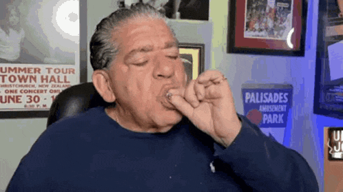 a man is eating something in front of a sign that says palisades amusement park .