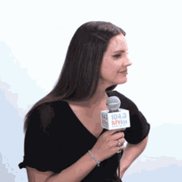 a woman holding a microphone that says 104.3 myim