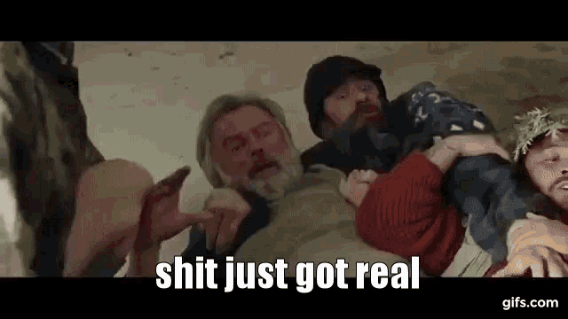 a man with a beard is being held by a group of people .