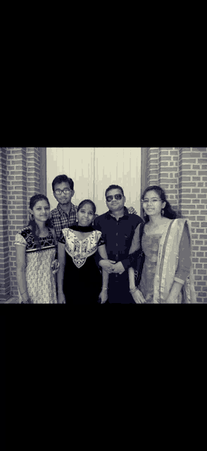 a group of people posing for a photo in front of a brick building