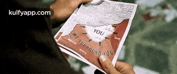a person is holding a piece of paper that says ' you we surround you ' on it