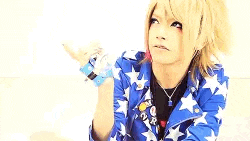 a girl with red and blonde hair is wearing a blue and white jacket with stars .