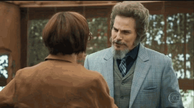 a man with a beard is talking to a woman