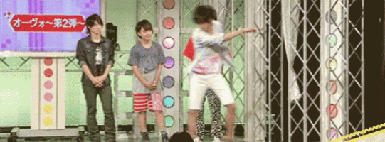 a group of people standing on a stage with a sign that says ' オーヴォ ~ 第 2 弾 ~ '