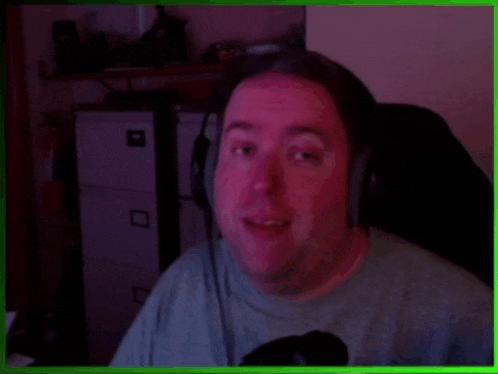 a man wearing headphones looks at the camera in a green frame