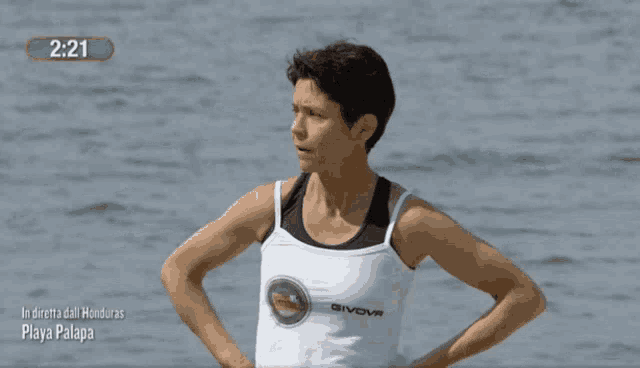 a woman wearing a givova tank top stands on the beach