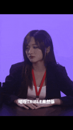 a woman sitting at a table with a red lanyard around her neck that says ' able ' on it