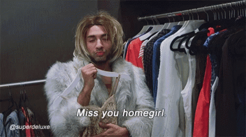 a man in a fur coat says " miss you homegirl " in front of a rack of clothes