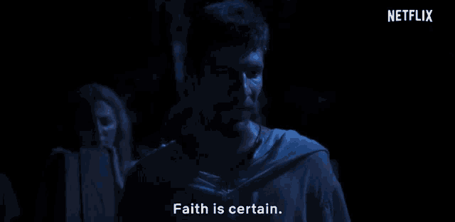 a man in a dark room with a netflix logo behind him