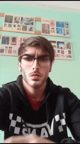a young man wearing glasses and a black hoodie with the word av on it