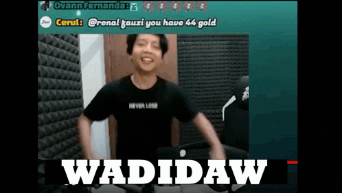 a man in a black shirt is dancing in front of a microphone while wearing a wadidaw shirt .