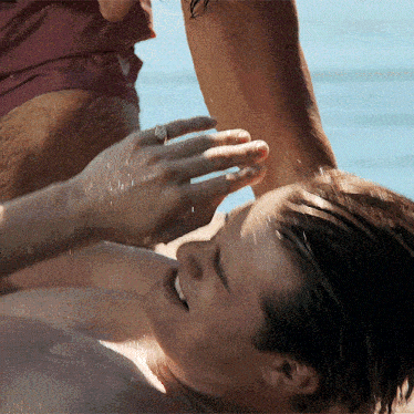 a man with a ring on his finger is laying on the ground