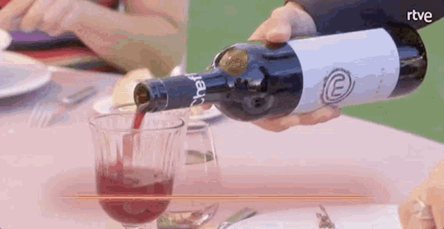 a bottle of wine is being poured into a glass