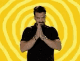 a man is praying in front of a yellow spiral .