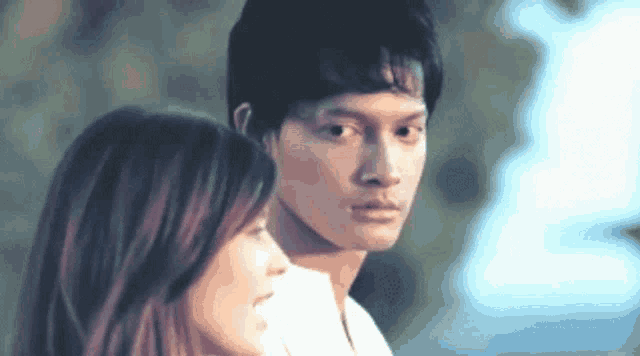 a man and a woman are looking at each other in a close up .
