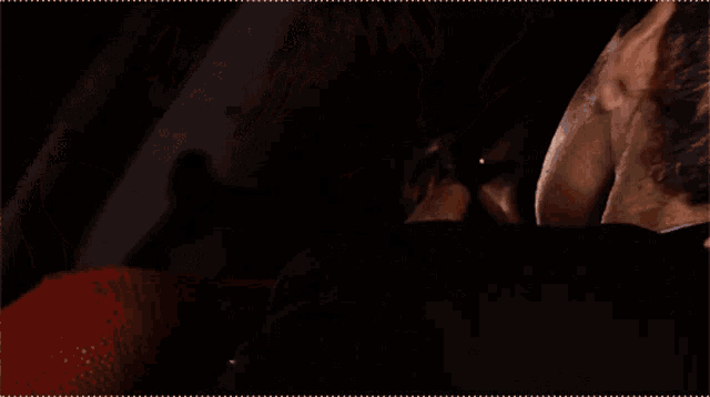 a man and a woman are kissing in a dark room