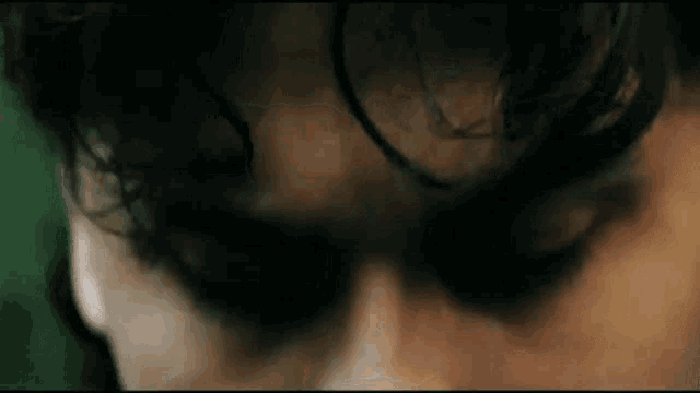 a close up of a person 's face with their eyes closed and a green background .