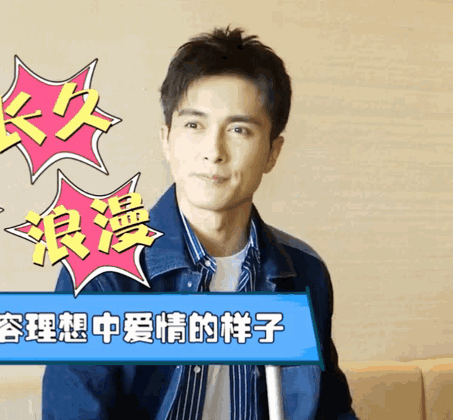 a man in a denim jacket is sitting in front of a sign with chinese characters on it