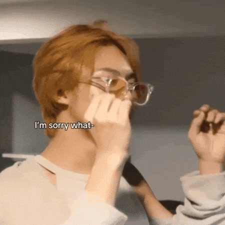 a man wearing glasses covering his mouth with his hand and the words " i 'm sorry what " written below him