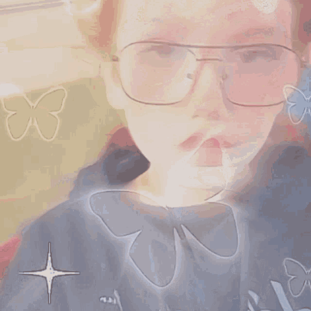 a person wearing glasses and a hoodie with a butterfly on it