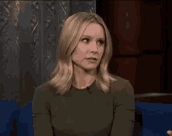 a woman is sitting in a chair with a microphone in her hand .