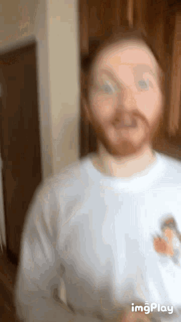 a man with a beard is wearing a white shirt with a pumpkin patch on it