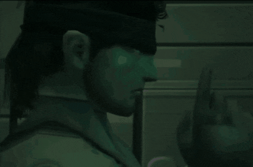 a man with a headband on his head is making a gesture with his hand