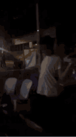 a group of people are sitting in a dark room at night