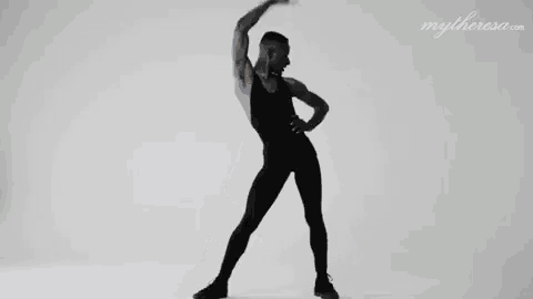 a man in a black leotard is dancing in front of a white background .