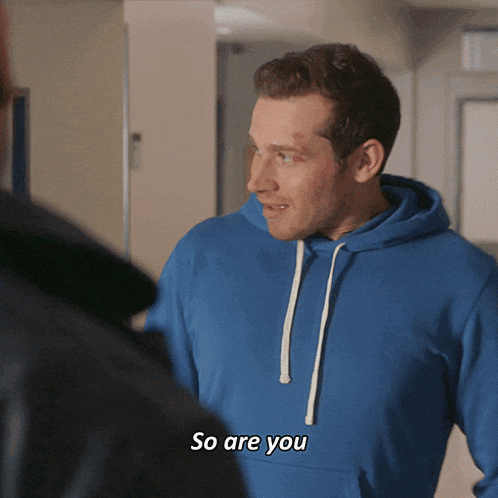 a man in a blue hoodie is talking to another man and says so are you