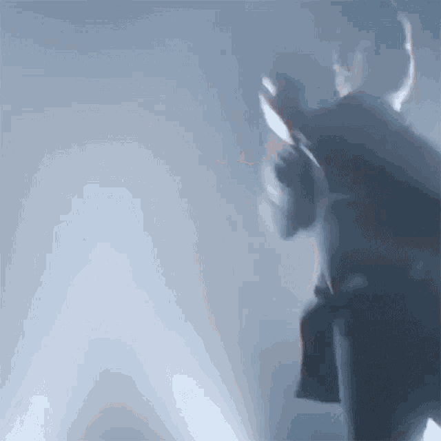 a man in a suit is standing in a dark room holding a gun .