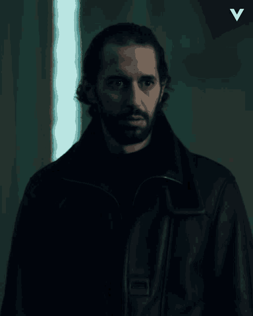 a man with a beard wearing a black jacket