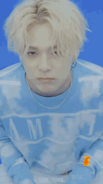 a man wearing a blue sweater with the word amber on it is surrounded by gummy bears