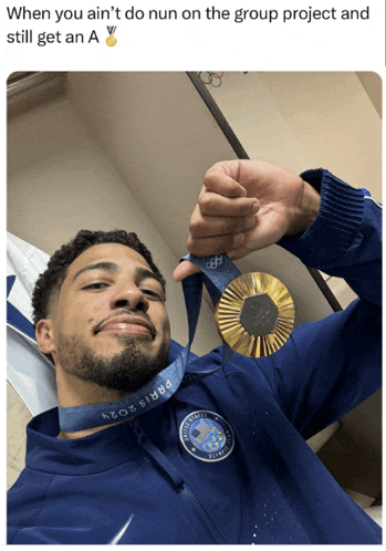 a man in a blue jacket is holding up a gold medal
