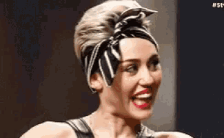 a close up of a woman wearing a bandana and smiling .