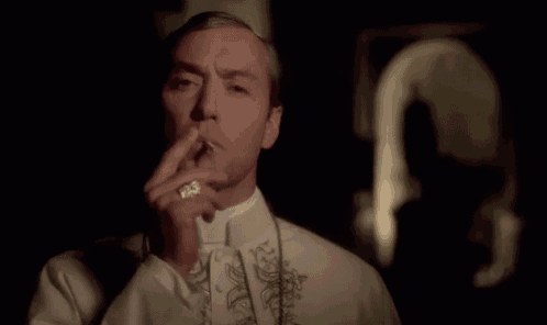 a man in a white shirt is smoking a cigarette