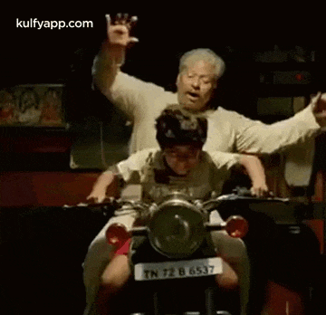 a man is riding a motorcycle with a boy on the back .