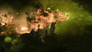 a group of people standing in front of a huge fire