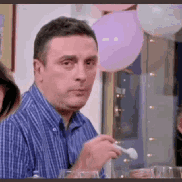 a man is eating with a spoon at a party .