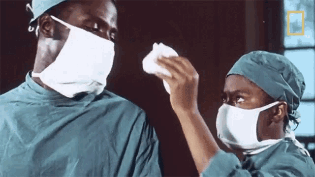 a man and a woman wearing surgical gowns and masks with a national geographic logo in the corner