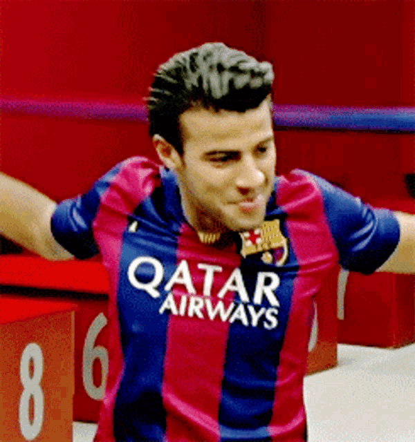 a soccer player wearing a qatar airways jersey with his arms outstretched